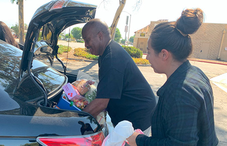 Pastor Davis putting food in automobile trunk